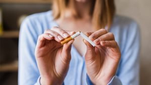 Stop Smoking Secret Solution - Woman breaking a cigarette